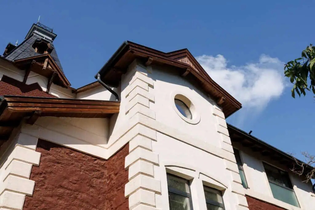 Beautiful house exterior showcasing plaster and lath wall finishes with detailed architectural featu.